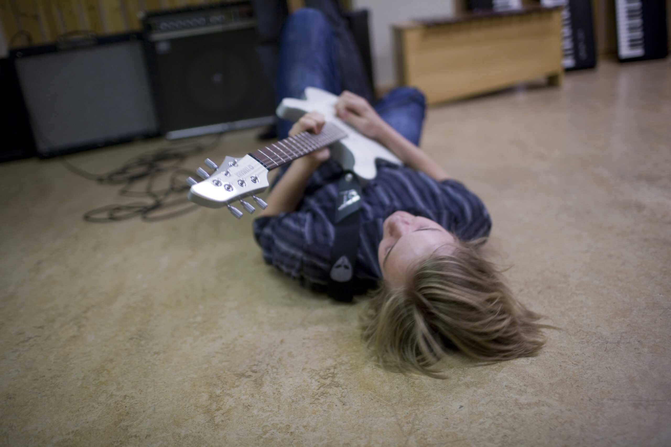 Ung gitarist liggende på gulvet